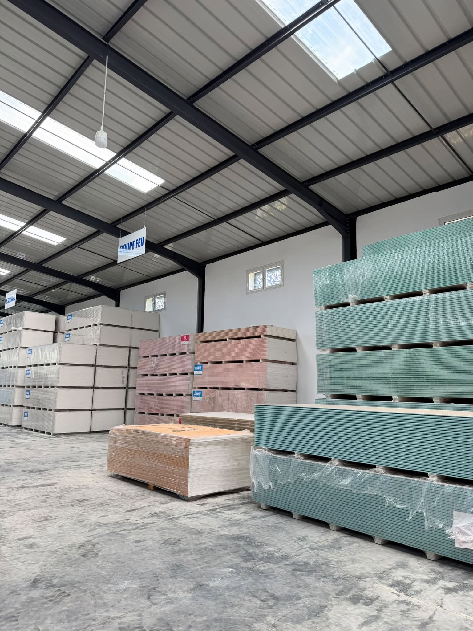 Stock de plaques de plâtre sur palettes dans l'entrepôt CSCD